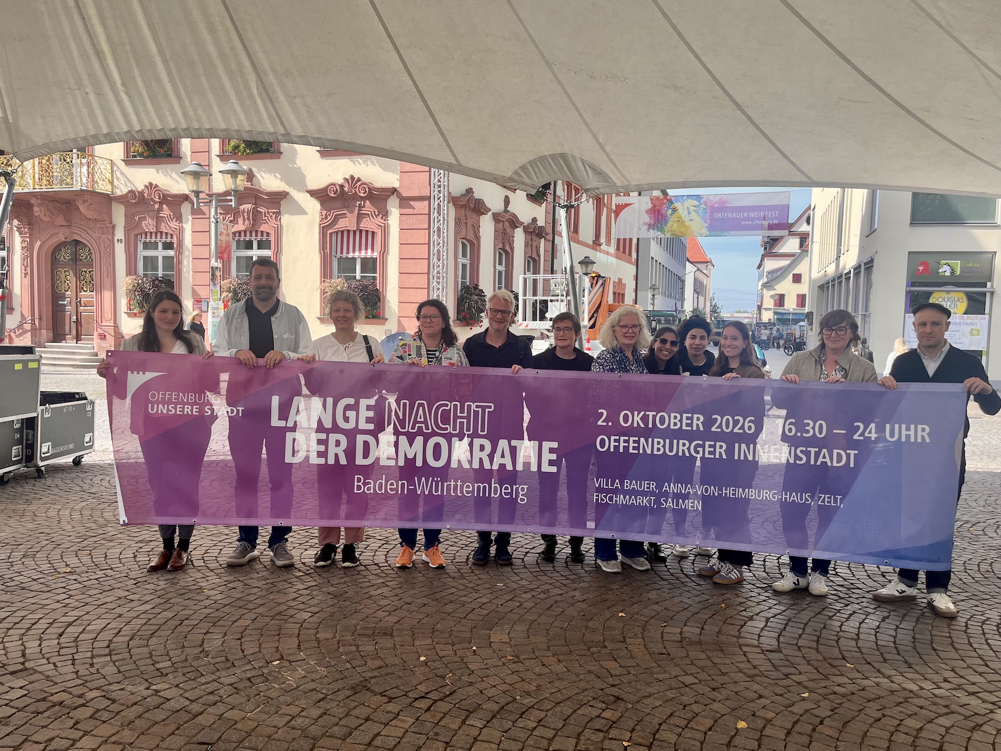 Andreas Heck und weitere Beteiligte der „Langen Nacht der Demokratie“ halten bei der Auftakt-Pressekonferenz in Offenburg gemeinsam das Veranstaltungsbanner.