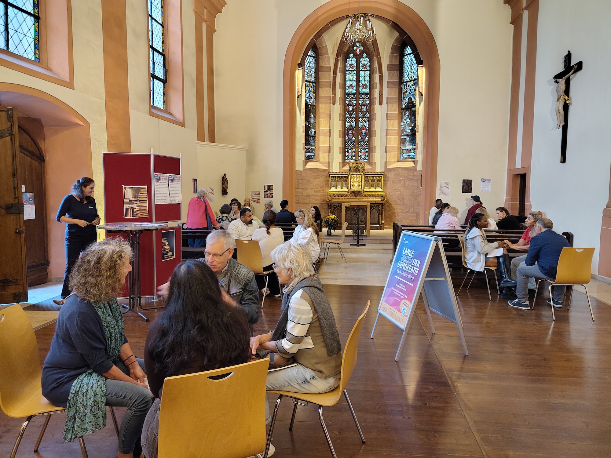 Blick in die St. Andreas Kirche auf mehrere Gesprächsrunden der „Langen Nacht der Demokratie“ mit Alex Djeumeni, Pamela Njieyong und weiteren „lebendigen Büchern“.
